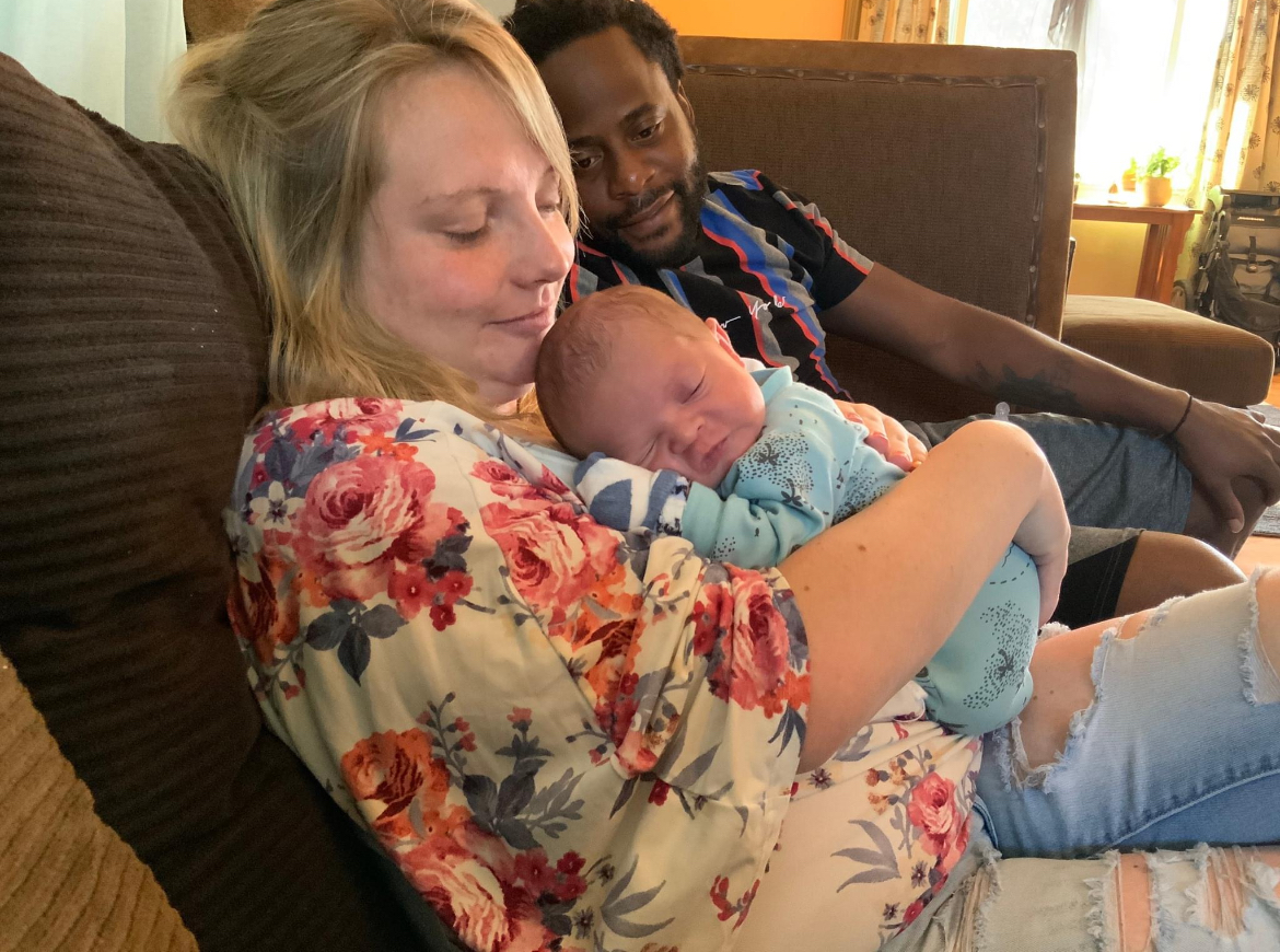 New parents holding their newborn at home